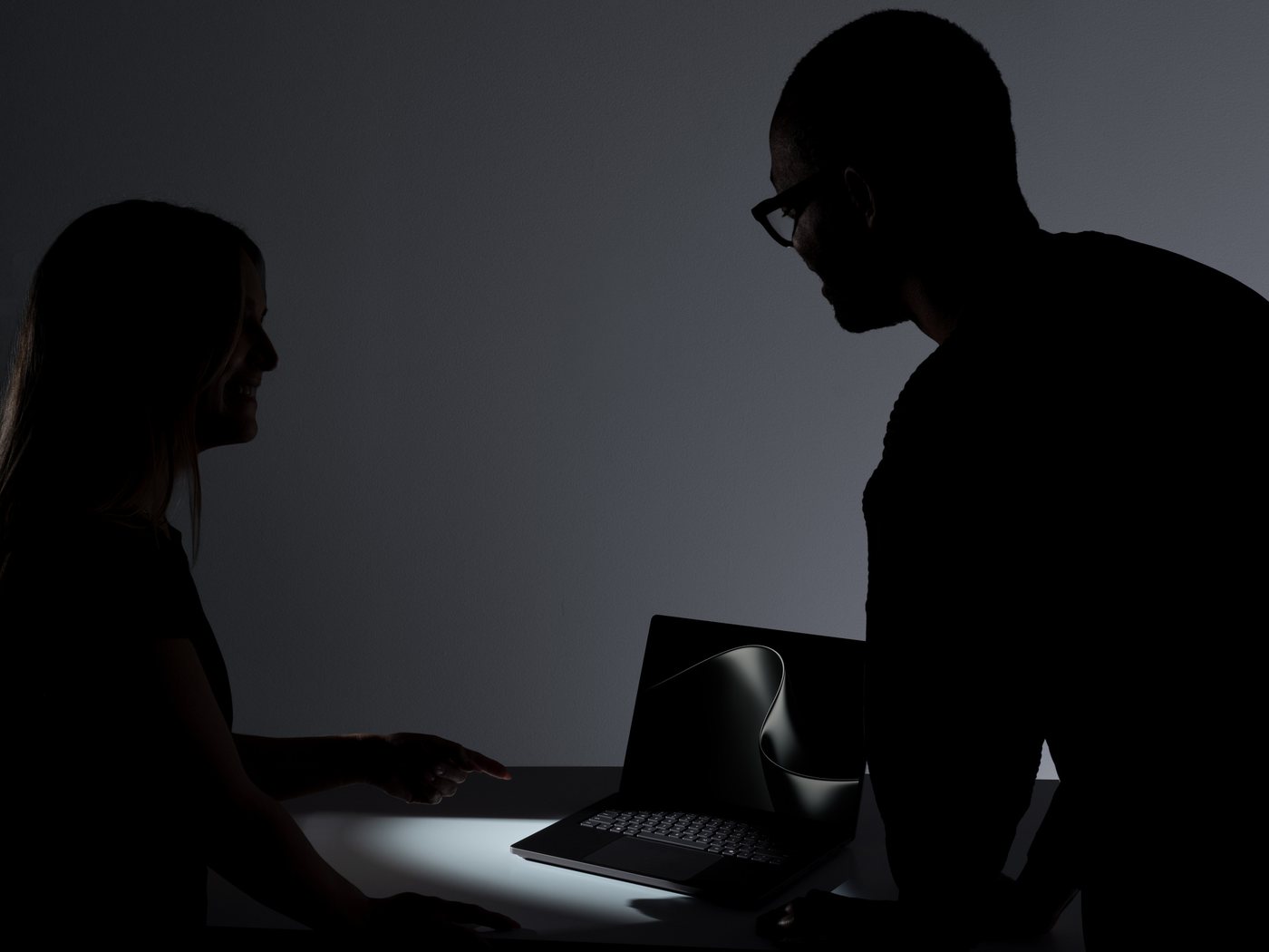 Two colleagues discussing work on a Surface Laptop Ultra